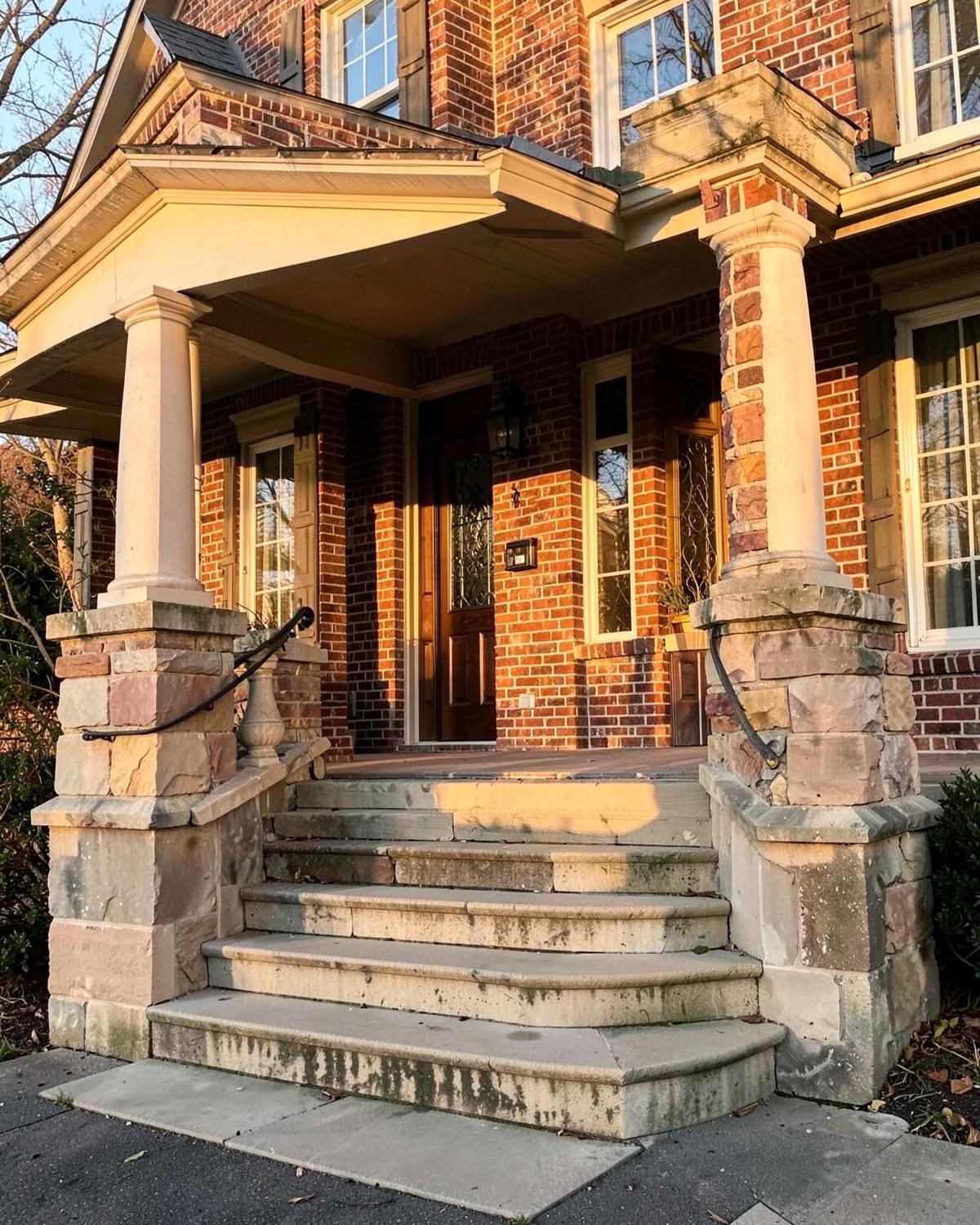 Brick front porch with limestone steps and stone piers